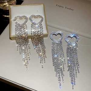 Sparkling zircon heart tassel drop earrings in silver and gold finishes on a display box