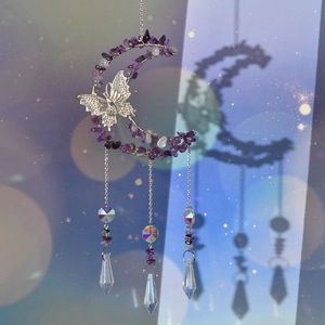 Macro view of handmade moon and butterfly suncatcher with purple amethyst and crystal prisms