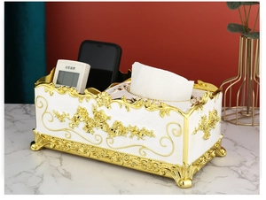 Detail of luxury white tissue box with gold rose relief and remote storage sections
