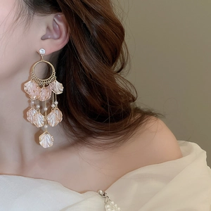 Close-up of pink petal tassel earrings with pearls and gold finish on a model