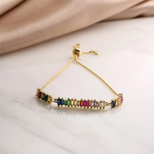 Detail of adjustable gold-plated bracelet featuring multi-color rectangular zircon stones