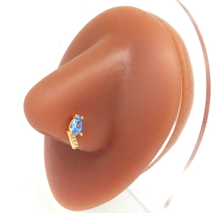 Golden heart nose ring with blue teardrop gemstone and crystals on a silicone model