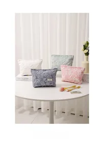 Detailed texture of jacquard floral makeup bags in white, green, blue, and pink colors