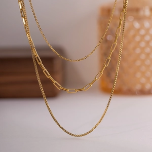 Detailed close-up of 18K gold layered necklace with paperclip and box chain links