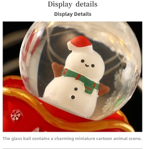 Macro shot of a Christmas snowman snow globe with a red base and gold accents
