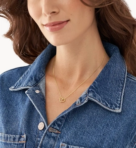 Close-up of minimalist gold hollow heart pendant necklace worn on a female neck