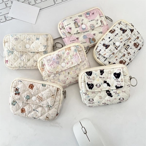 Macro detail of quilted cotton coin purses with snap buttons and floral animal prints