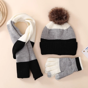 Detailed close-up of winter knit set featuring striped pattern and faux fur pom pom