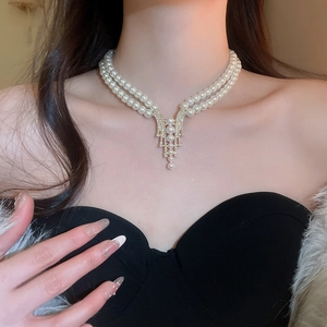 Elegant double-layer pearl necklace with a rhinestone fringe pendant worn by a model