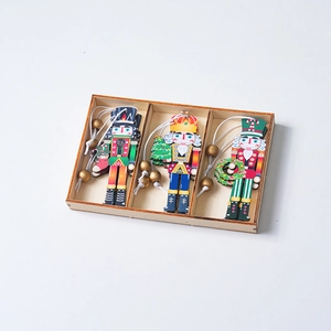 Detailed view of three painted wooden nutcracker soldier ornaments in a wooden storage box
