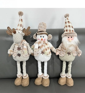 Dettaglio di bambole natalizie in peluche con sciarpe a quadri e ricami di fiocchi di neve