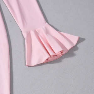 Gros plan détaillé d'une robe rose à manches longues avec poignets évasés à volants