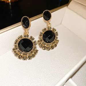 Macro detail of vintage black oval gemstone earrings with crystal halo in jewelry box