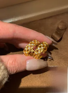 Macro shot of gold plated hollow woven ring with micro-set white zircon stones