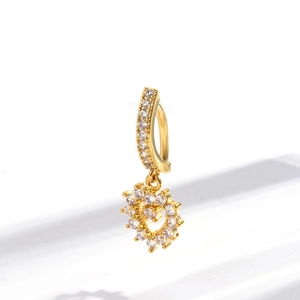 Close-up of gold-plated navel ring with sparkling zircon heart-shaped pendant