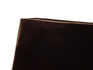 Detailed macro shot of dark brown velvet fabric texture and quality edge stitching