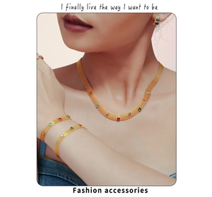 Gros plan sur l'ensemble collier et bracelet en maille dorée avec zircons colorés
