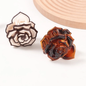 Elegant rose flower hair claws in cream coffee and amber colors on a wooden tray