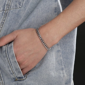 Minimalist silver stainless steel Cuban link bracelet worn on wrist with street style