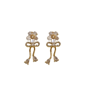 Boucles d'oreilles nœud doré avec fleur en perle blanche et gouttes en cristal brillant