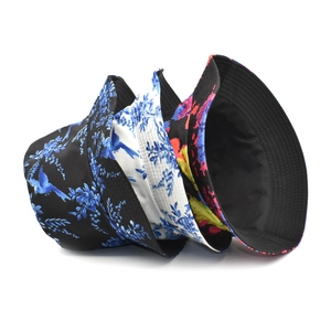 Three bucket hats with bird and floral patterns in black and white backgrounds