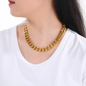 Close-up of a chunky golden Cuban link necklace with CNC diamonds worn by a model