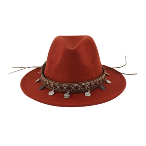 Close-up of rust wool felt hat with ethnic embroidery, silver coins and metal bead chain
