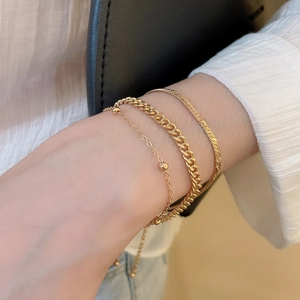 Gros plan d'un ensemble de bracelets dorés avec maille gourmette et chaîne serpent