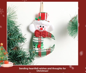 Detail of moon-shaped knitted Christmas ornament with snowman head and red bow