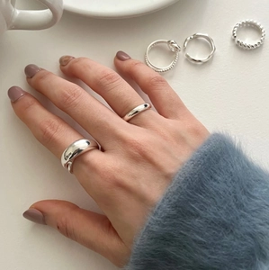 Detail of minimalist silver stackable rings with textured and smooth finishes on model
