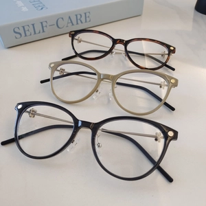 Three pairs of vintage round eyeglasses in black, tortoiseshell, and beige finishes