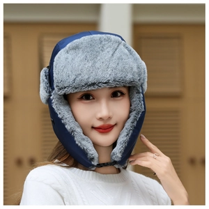 Close-up of winter trapper hat featuring blue waterproof fabric and thick grey faux fur lining
