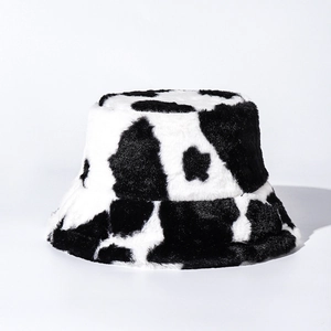 Close-up of soft faux fur texture and black and white cow print on the plush bucket hat