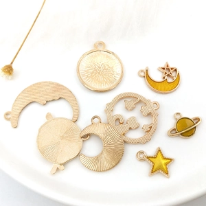 Detail of celestial enamel charms including sun moon and stars on ceramic tray