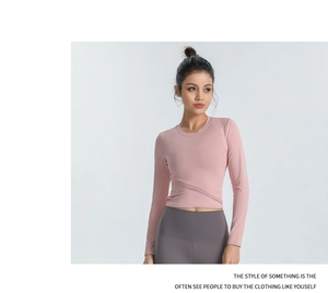 Détail du haut de yoga rose clair avec taille croisée et texture en maille, coupe ajustée