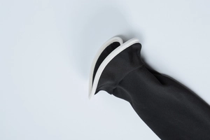 Close-up of black knitted fabric with contrasting white piped edges and soft texture