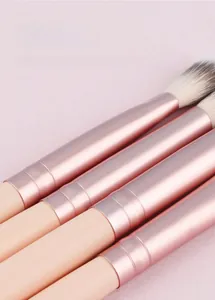 Détail des viroles en aluminium or rose et poils synthétiques doux des pinceaux à maquillage