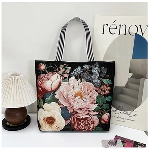 Close-up of ethnic tote bag with detailed floral 3D embroidery on black canvas