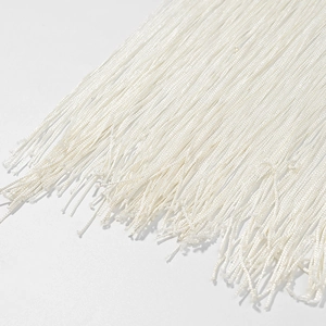 Vue détaillée macro d'une bordure à franges blanches montrant la texture des fils