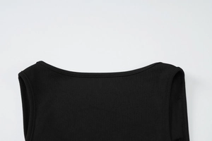 Dettaglio dello scollo e della spalla su abito in maglia a coste nere con cuciture fini