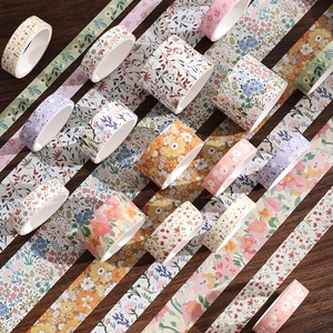 Washi tape set with floral and botanical patterns on a dark wood background