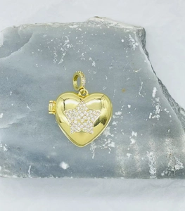Detailed view of a gold heart photo locket pendant with a sparkling zircon star pattern