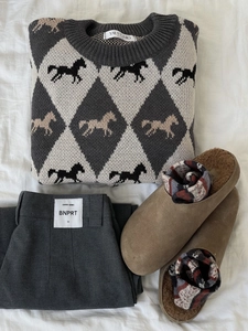 Flat lay of gray rhombus knit sweater with matching pants and wool socks on white fabric