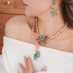Close-up of vintage gold peacock jewelry set with colorful crystals and fringe