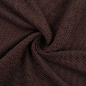 Gros plan détaillé sur la texture du tissu côtelé marron foncé pour ensemble haut et jupe