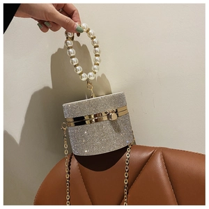 Macro view of silver cylinder clutch bag with rhinestones and pearl handle detail