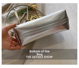 Detailed close-up showing the rectangular base and neat stitching of the silver handbag