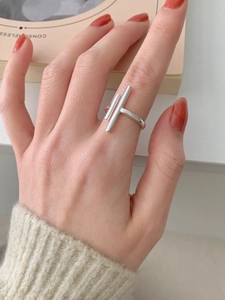 Macro shot of silver minimalist double-bar geometric open ring worn on a hand