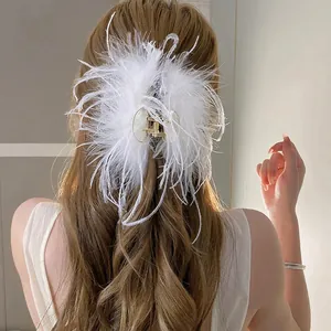 Elegant white ostrich feather hair claw clip for women's updo hairstyles in soft lighting