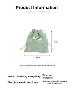 Detailed view of green drawstring polyester pouch showing 14cm by 16cm dimensions